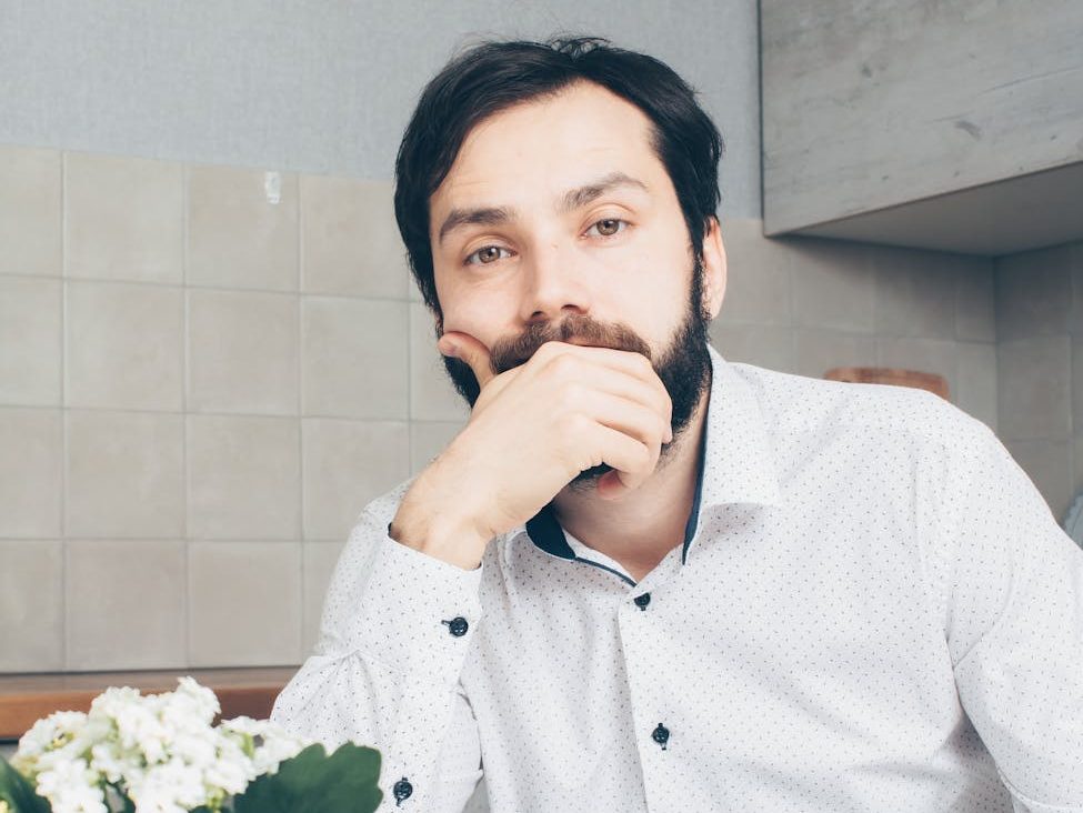 man in white dress shirt sitting at the table