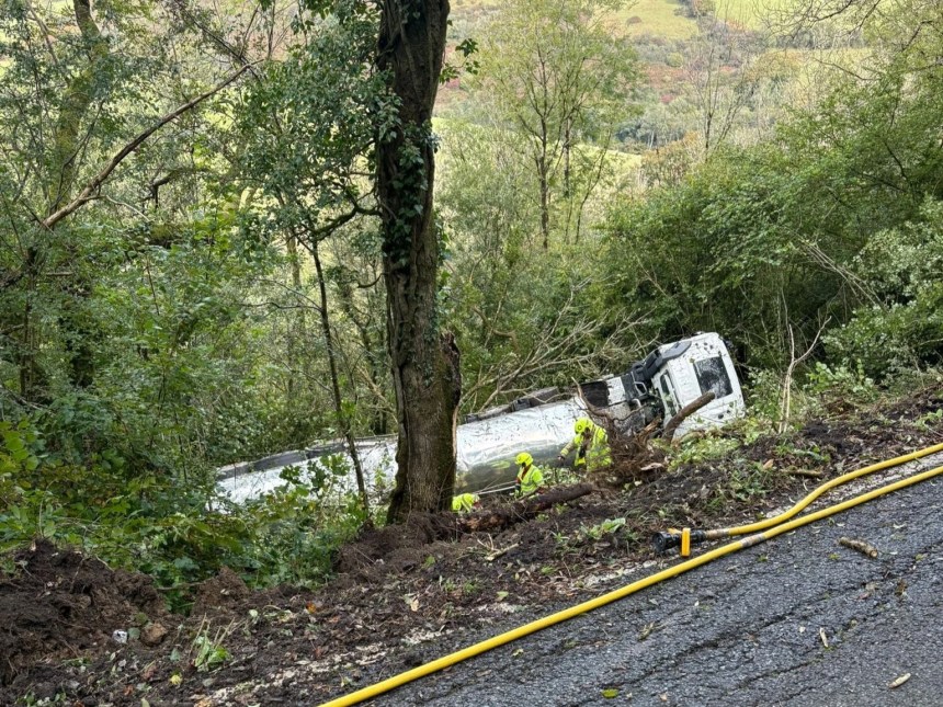 Fire crews and police at the scene of a milk tanker crash near Carmarthen after the vehicle slid down an embankment.