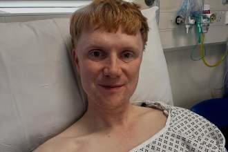 BBC presenter Owain Wyn Evans wearing a hospital gown in Cardiff’s Llandough Hospital after emergency gallbladder surgery.