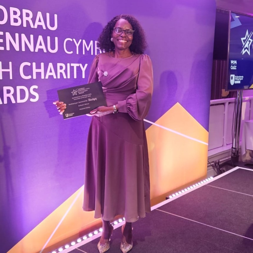 Mojisola Olateju smiling and holding her Volunteer of the Year award at the Welsh Charity Awards ceremony.