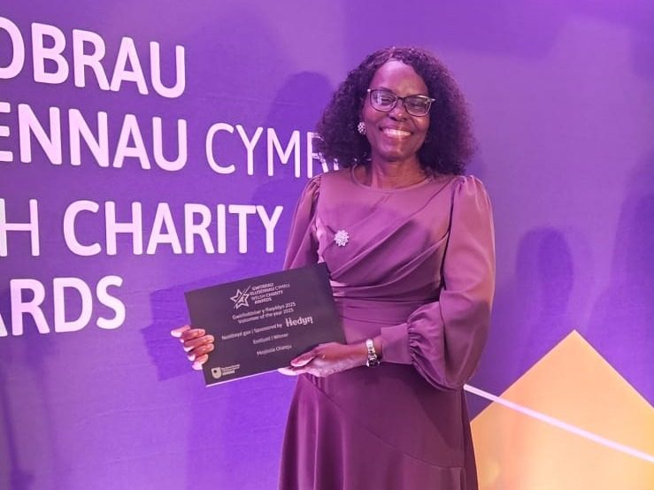 Mojisola Olateju smiling and holding her Volunteer of the Year award at the Welsh Charity Awards ceremony.