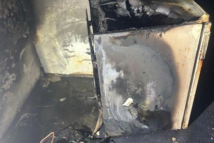 Basement room in Neath showing extensive fire damage after a dehumidifier blaze, with walls and ceiling blackened by smoke.