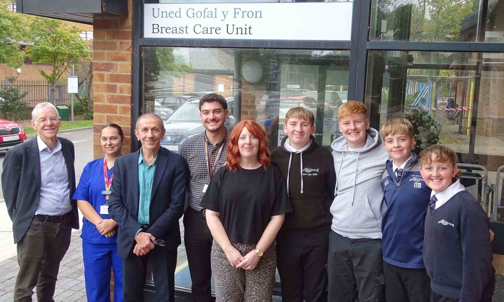 Family photo of Meinir Morgan with her four teenage sons alongside staff from Singleton Hospital’s Breast Care Unit.