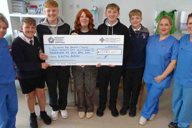 Meinir Morgan with sons Iestyn, Lewis, Rhys and Ioan handing over a cheque to staff at Singleton Hospital’s Chemotherapy Day Unit.