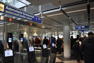 Passport control desks inside Munich International Airport, Terminal 1, with barriers and booths for arriving passengers.