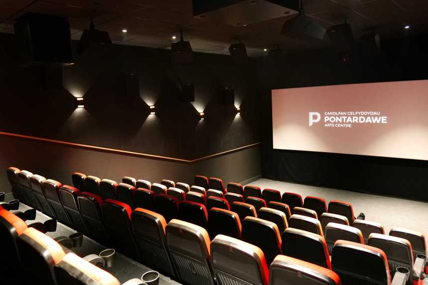 View of the new tiered seating inside Pontardawe Arts Centre’s 74‑seat cinema, with the big screen showing “Pontardawe Arts Centre”.