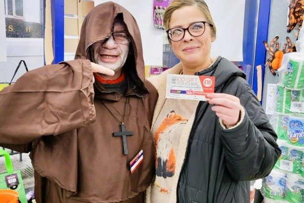 A customer in Swansea holding a £10 Poundstretcher voucher after winning the store’s Halloween giveaway promotion.