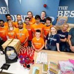 Table of school supplies at Amazon Swansea prepared for packing into 950 backpacks donated to Cwtch Mawr Multibank.