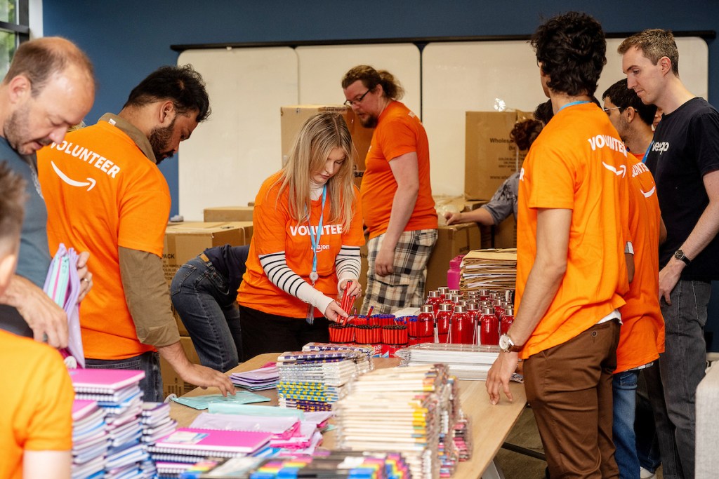 Amazon Swansea volunteers pack backpacks with school essentials for the Kits for Kids campaign in partnership with Cwtch Mawr Multibank.