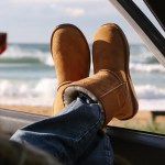 A woman wearing Ugg boots sits in a car with her feet out of the window, illustrating expert warnings that loose‑fitting footwear can put drivers at risk of fines.