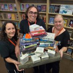 Three Swansea Central Library staff members packing books and preparing for relocation to Y Storfa.