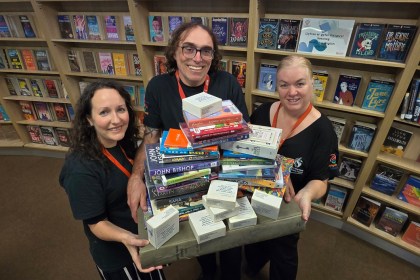 Three Swansea Central Library staff members packing books and preparing for relocation to Y Storfa.