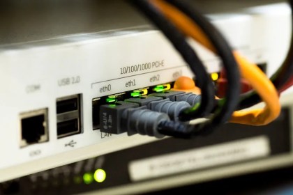Stock image showing the back of a broadband router with cables connected.