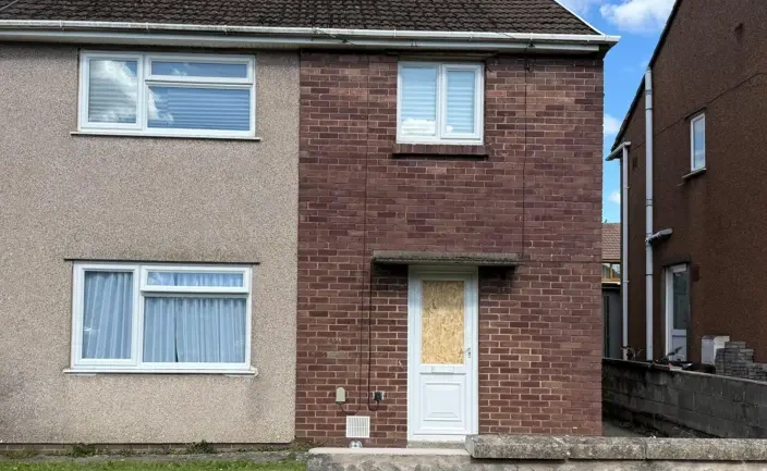 A boarded‑up front door at a house in Pyle where South Wales Police recovered bullets after a reported shooting in September 2025.