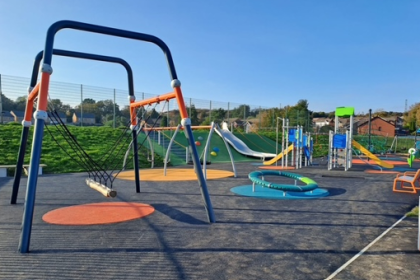 Wide view of Parc Gwernfadog playground with multiple new play structures.