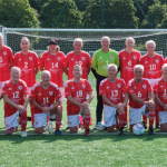 Wales Over‑70s football squad pictured together in Japan, celebrating back‑to‑back World Cup triumphs after defeating England in the final.