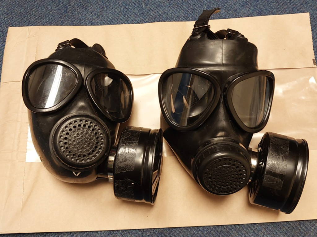 Two gas masks photographed as evidence after being recovered from a rucksack.