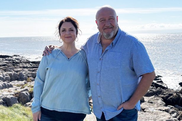 Ruth Jones and Steve Speirs stand arm in arm by the sea in Wales, promoting their upcoming BBC Wales comedy about friendship and life in middle age.