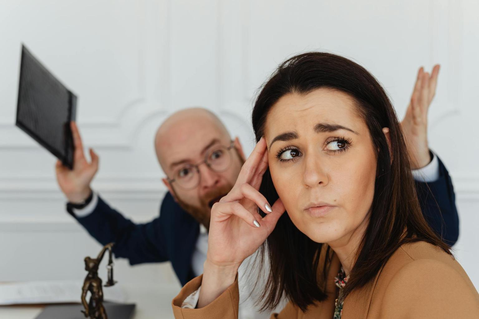 shouting man behind sad woman