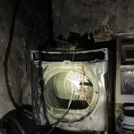 Burnt tumble dryer inside blackened outbuilding following fire in Penlan, Swansea.