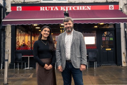 Front of Ruta Kitchen café in Swansea with Charlotte Price, Development Bank of Wales, and co‑founder Vladimir Pavliiciuc.