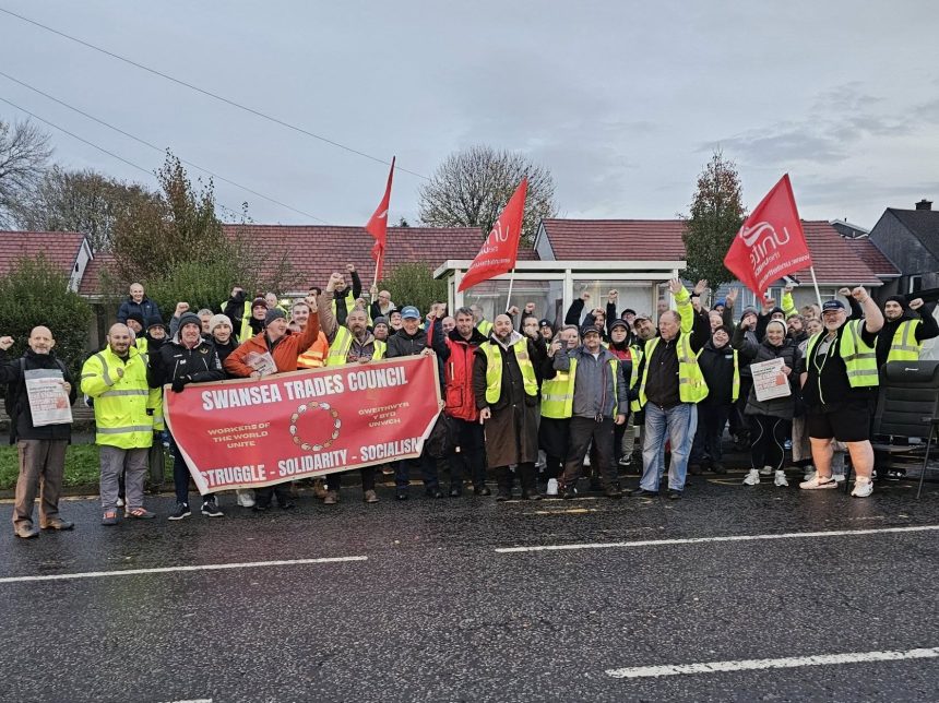 Group of striking First Cymru bus workers standing together on the picket line in South Wales.