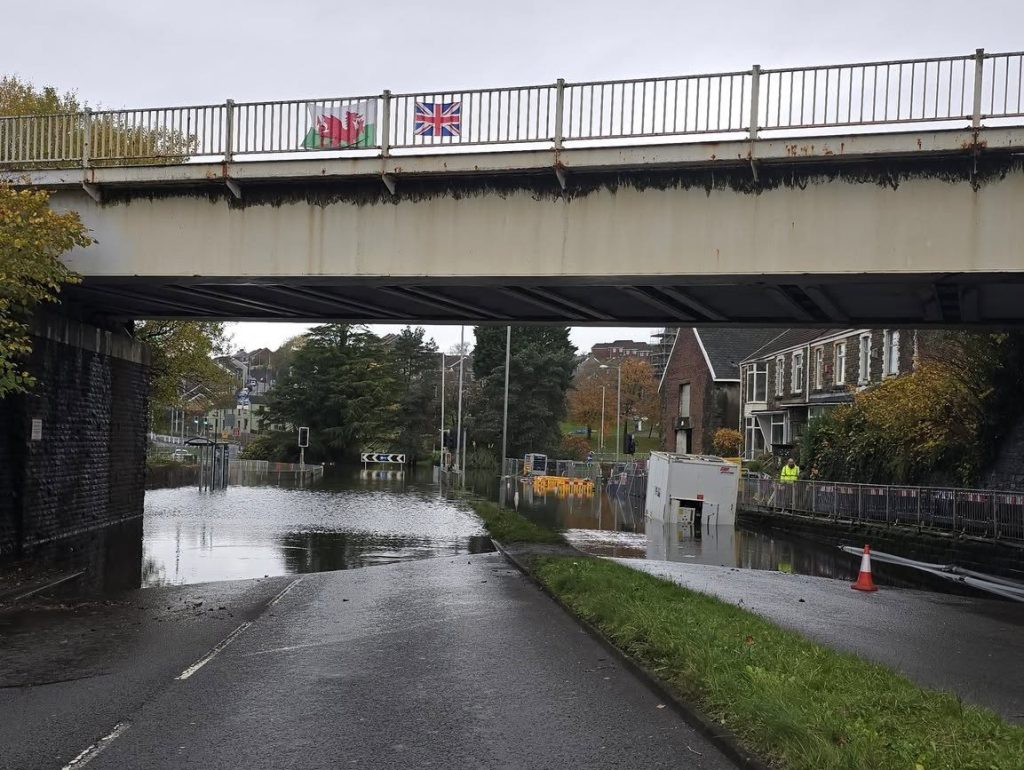View from the Cwmfelin side of the railway bridge showing Cwmbwrla roundabout submerged in floodwater with pumping equipment in place.