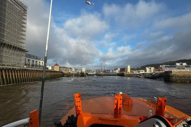 View from an RNLI lifeboat in the River Tawe at SA1, showing a helicopter overhead during the search operation.