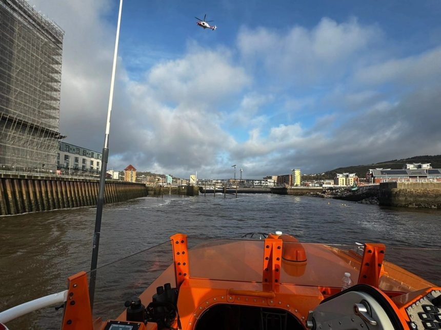 View from an RNLI lifeboat in the River Tawe at SA1, showing a helicopter overhead during the search operation.