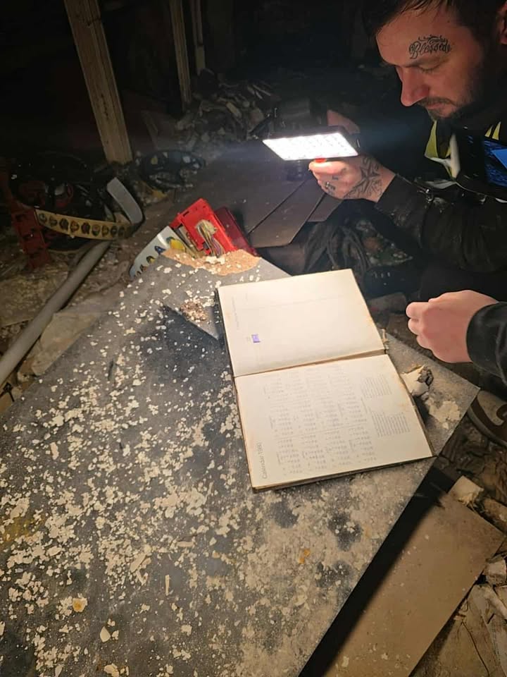 Open calendar book labeled “Calendar 1980” on dusty table in abandoned room