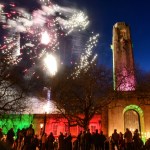 Fireworks above illuminated Guildhall tower with crowd gathered below during festive event.