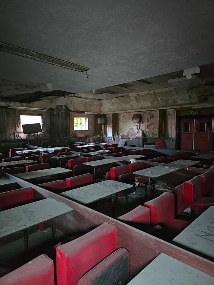 Decaying dining room inside Elysium Theatre reveals haunting traces of its communal past.