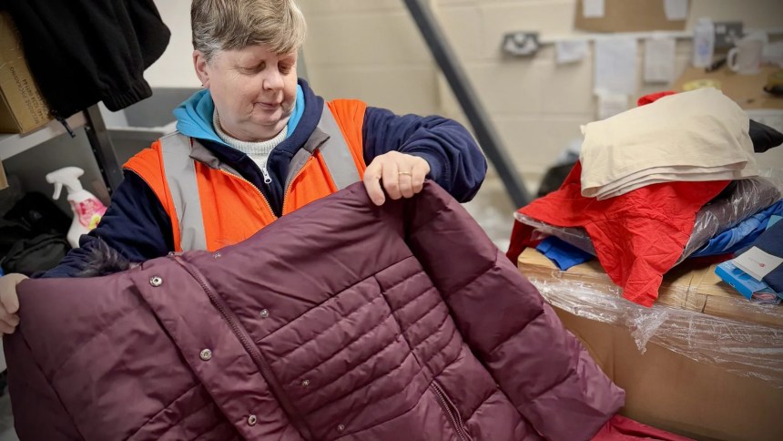 Volunteer sorting winter clothing at Cwtch Mawr Multibank in Swansea