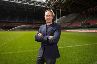 Dave Reddin, WRU Director of Rugby and Elite Performance, wearing a suit while standing on the rugby field.