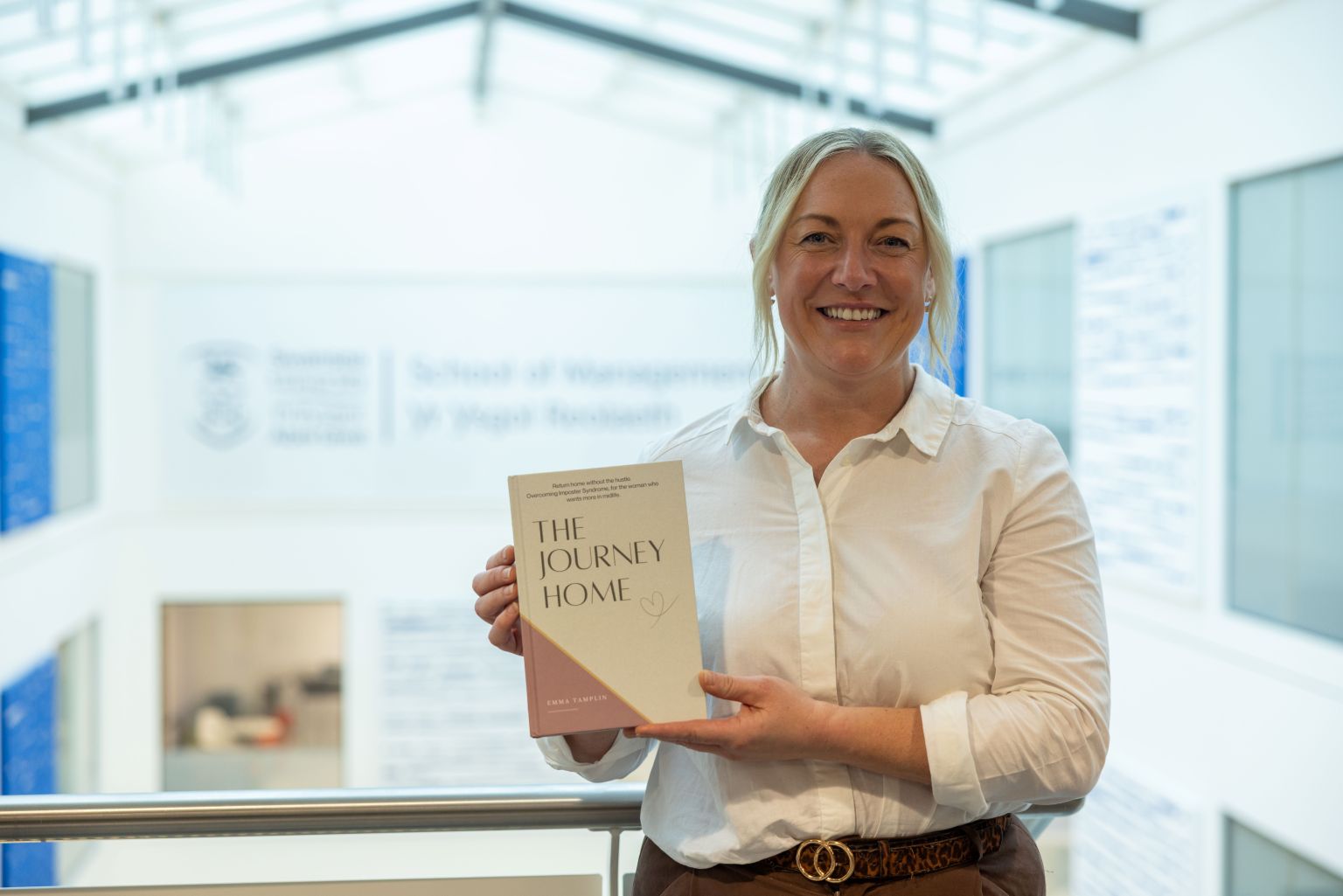 Emma Tamplin holding her book The Journey Home outside Swansea University.