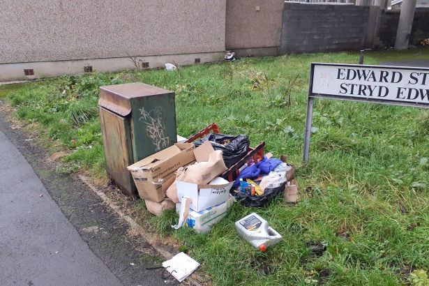 Litter and dumped materials on Edward Street, Port Talbot, including cardboard boxes, clothing and motor oil.