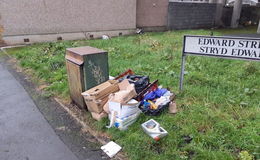 Litter and dumped materials on Edward Street, Port Talbot, including cardboard boxes, clothing and motor oil.
