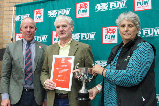 Photograph of Carmarthenshire farmer Haydn Evans receiving the 2025 FUW–United Counties Agriculture and Hunters Society Award at Carmarthen Market.