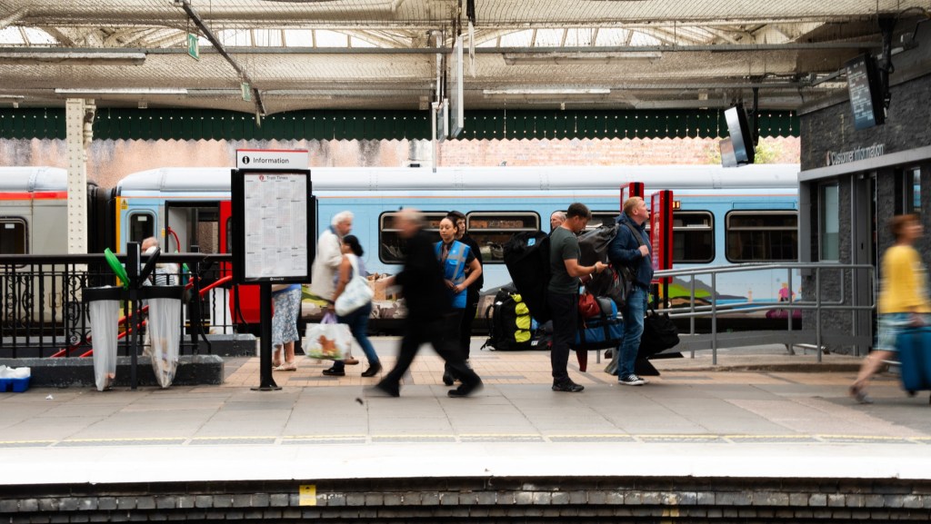 Passengers wait and board a train at a busy station on the Wales and Borders network.