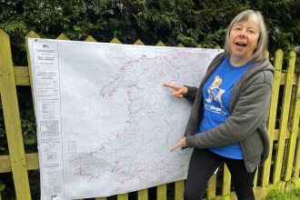 Janet Baldock pointing to a location on a Wales Coast Path map during her charity walk
