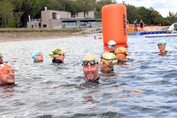 A group of swimmers in Lisvane and Llanishen Reservoir, Cardiff, with clear water and surrounding greenery, reflecting its new ‘excellent’ bathing water status.