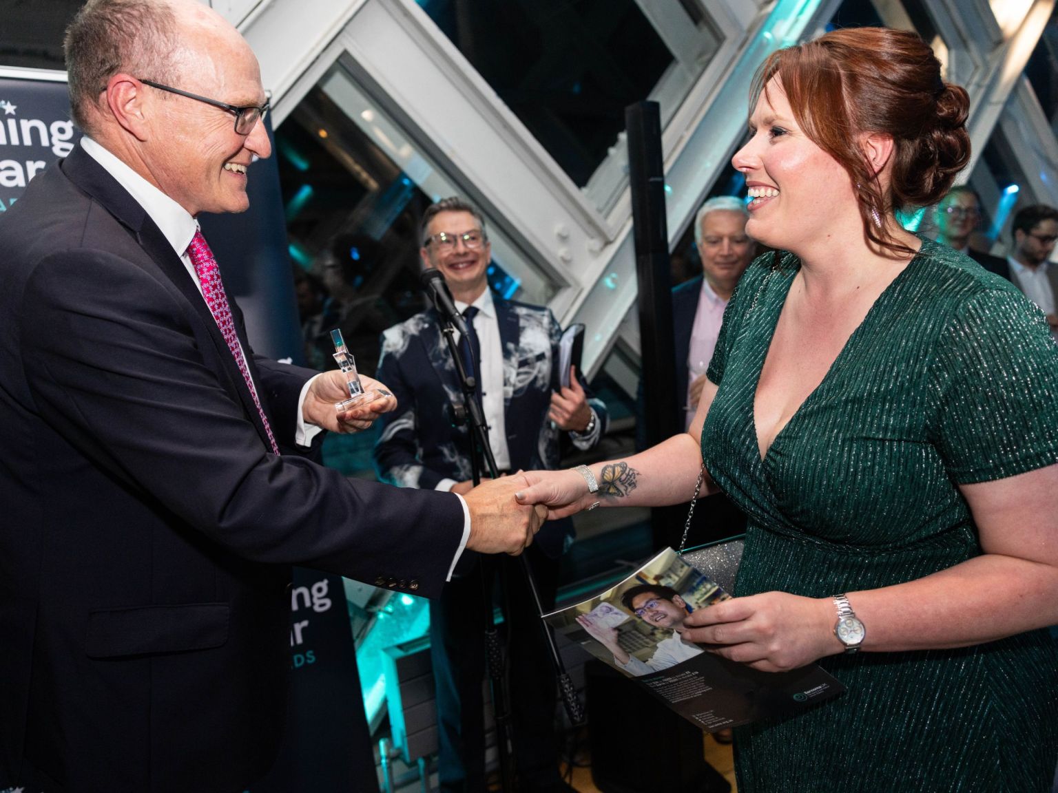 Side view of Lucy Whiddett receiving an award from Sarcoma UK Trustee Gary Davison.