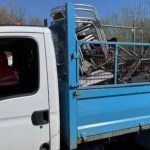 Side view of a Transit tipper truck. Leon Medlam, wearing an orange hi‑vis jacket, is seated in the driver’s seat speaking to an enforcement officer at the window.