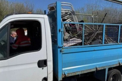 Side view of a Transit tipper truck. Leon Medlam, wearing an orange hi‑vis jacket, is seated in the driver’s seat speaking to an enforcement officer at the window.