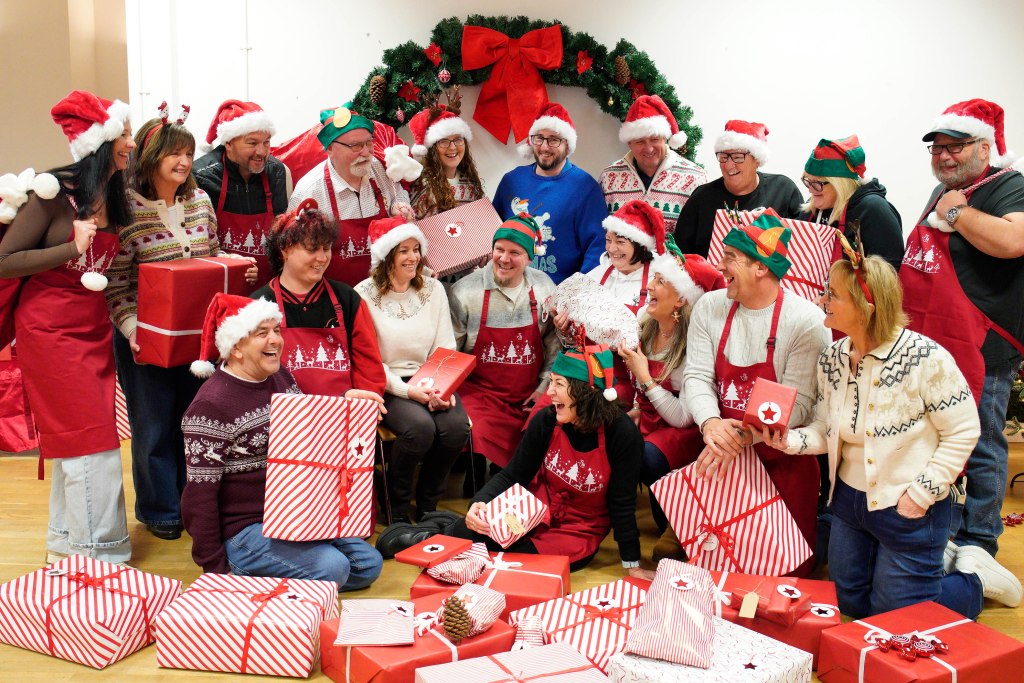 Group of National Lottery winners wrapping and packing toy gift boxes at ToyBox Project in Caerphilly.