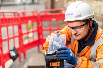 Openreach engineer installing fibre equipment in Clydach street work zone
