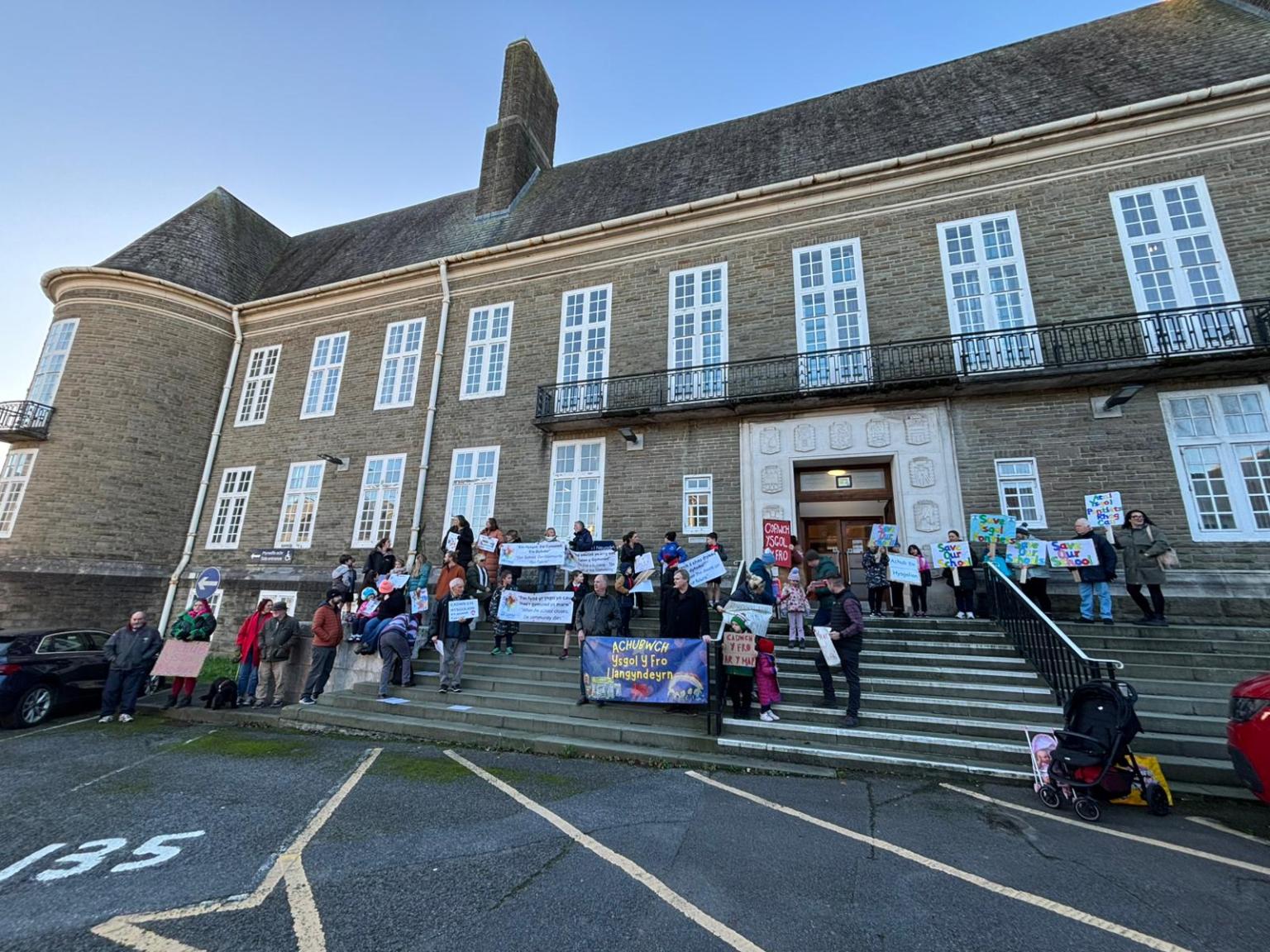 Parents holding banners during a protest outside Carmarthenshire County Council’s County Hall in Carmarthen.