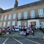 Parents holding banners during a protest outside Carmarthenshire County Council’s County Hall in Carmarthen.