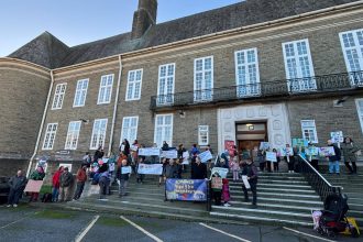 Parents holding banners during a protest outside Carmarthenshire County Council’s County Hall in Carmarthen.