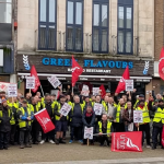 Group of First Cymru bus drivers on strike in Swansea, standing on Kingsway with Unite union banners.